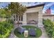 Stylish front porch with outdoor seating, sleek columns, a tree, and lush landscaping at 1900 Vero Dr, Las Vegas, NV 89134