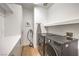 Bright laundry room featuring modern washer and dryer, built-in storage, and space-saving ironing board at 1900 Vero Dr, Las Vegas, NV 89134