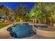 Backyard pool and hot tub area beautifully lit with mature trees creating a relaxing ambiance at twilight at 1900 Vero Dr, Las Vegas, NV 89134
