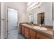 Bathroom with double sinks, granite counters, and a view into a walk-in closet and toilet area at 2086 Angel Falls Dr, Henderson, NV 89074