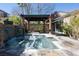 Beautiful backyard showcases a jacuzzi with a stone waterfall feature under a covered pergola at 2279 Pacini Ct, Henderson, NV 89052