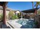 Serene backyard features a jacuzzi under a covered structure, surrounded by lush landscaping at 2279 Pacini Ct, Henderson, NV 89052