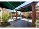 Outdoor oasis featuring a covered lounge, water feature, and lush tropical landscaping at 2279 Pacini Ct, Henderson, NV 89052