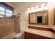 Cozy bathroom showcasing a shower over tub, cherry vanity, and soft, ambient lighting at 2279 Pacini Ct, Henderson, NV 89052