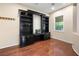 Well-appointed home office featuring built-in shelving, hardwood floors, and a bright window with a view at 2279 Pacini Ct, Henderson, NV 89052