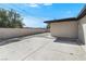 Backyard view showing a white block wall, gravel area and concrete patio at 2729 Flower Ave, North Las Vegas, NV 89030