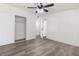 Bedroom showcasing wood-look floors, sliding door closet, modern ceiling fan, and access to hallway at 2729 Flower Ave, North Las Vegas, NV 89030