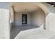 Arched covered entryway with concrete floor and glass paneled front door at 2729 Flower Ave, North Las Vegas, NV 89030