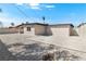 Exterior view showcasing the home's gravel yard, concrete patio, and fenced perimeter at 2729 Flower Ave, North Las Vegas, NV 89030