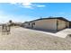 Well-maintained single-story house with a large, gravel-covered side yard and secure fencing at 2729 Flower Ave, North Las Vegas, NV 89030