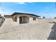 Charming exterior featuring a gravel yard, an arched entryway, and a small window at 2729 Flower Ave, North Las Vegas, NV 89030
