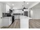 Well-lit kitchen featuring white cabinetry, stainless appliances, a quartz countertop island and subway tile backsplash at 2729 Flower Ave, North Las Vegas, NV 89030