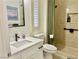 Bright bathroom features a white vanity, sleek fixtures, and tiled shower with convenient grab bar at 2736 Darby Falls Dr, Las Vegas, NV 89134