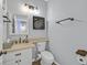 Charming bathroom with tan granite vanity, vanity mirror, decorative art, and convenient toilet paper holder at 2875 Cooper Creek Dr, Henderson, NV 89074