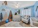 A Bedroom featuring a crib, rocking chair, and adventure themed wall art at 2875 Cooper Creek Dr, Henderson, NV 89074