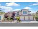 Charming two-story home with a three-car garage and well-manicured front yard landscaping and classic architectural details at 2875 Cooper Creek Dr, Henderson, NV 89074
