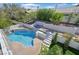 Backyard oasis featuring a sparkling pool, spa, waterfall feature, and lush landscaping, creating a private retreat at 2875 Cooper Creek Dr, Henderson, NV 89074