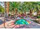 Close-up of a community hot tub with rock waterfall, mature palms, and lush landscaping at 2975 Bluegrass Ln # 412, Henderson, NV 89074