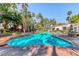 Resort-style pool with a rock waterfall feature surrounded by lush landscaping and palm trees at 2975 Bluegrass Ln # 412, Henderson, NV 89074