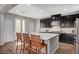Kitchen island with granite countertops and wood stools, illuminated by recessed lighting at 352 Sidewheeler St, Henderson, NV 89012