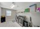 Functional laundry room with stainless steel washer/dryer and storage shelves at 352 Sidewheeler St, Henderson, NV 89012