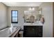 Bright main bathroom offers a soaking tub, double vanity with lots of storage, and a large window at 352 Sidewheeler St, Henderson, NV 89012