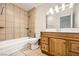Bathroom with tiled shower/tub, wood vanity, and a large mirror with lighting at 3577 Wayne Cir, Las Vegas, NV 89121