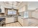 Bright kitchen features white cabinets, stainless steel appliances, granite counters, and view to the backyard pool area at 3577 Wayne Cir, Las Vegas, NV 89121