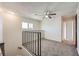 An upstairs loft space features neutral carpet, windows, and railings overlooking the stairs at 3577 Wayne Cir, Las Vegas, NV 89121