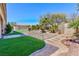 Landscaped backyard with artificial turf, desert landscaping, shed, and trees at 3662 Riley Ann Ave, Las Vegas, NV 89139