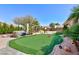 Landscaped backyard featuring artificial turf, desert landscaping and mature trees at 3662 Riley Ann Ave, Las Vegas, NV 89139