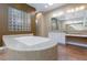 Elegant bathroom showcasing a large soaking tub, dual vanities, and a glass block accent wall at 3662 Riley Ann Ave, Las Vegas, NV 89139