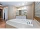Bright bathroom featuring a large soaking tub, dual vanities, and a glass block accent wall at 3662 Riley Ann Ave, Las Vegas, NV 89139