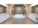 Luxurious bathroom featuring a large soaking tub, tiled flooring, and and vanities at 3662 Riley Ann Ave, Las Vegas, NV 89139