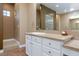 Bathroom featuring a granite countertop, white cabinets, and a walk-in shower with glass block accents at 3662 Riley Ann Ave, Las Vegas, NV 89139
