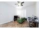 Cozy bedroom features wood floors, ceiling fan, and a charming green accent chair at 3662 Riley Ann Ave, Las Vegas, NV 89139