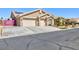Tan single-story home with a three-car garage and paved driveway provides ample parking at 3662 Riley Ann Ave, Las Vegas, NV 89139