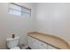 Functional half-bath featuring a toilet, vanity with granite countertop, and a window for natural light at 3662 Riley Ann Ave, Las Vegas, NV 89139