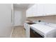 Well-equipped laundry room with a sink, washer, dryer, and ample storage cabinets at 3662 Riley Ann Ave, Las Vegas, NV 89139