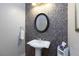 Stylish powder room featuring a decorative mosaic wall and an oval mirror at 3662 Riley Ann Ave, Las Vegas, NV 89139
