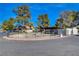 View of the community pool and pergola surrounded by mature trees and a black metal fence at 3667 Edinburgh Dr, Las Vegas, NV 89103