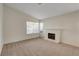 Bright and cozy living room featuring a brick fireplace, a large window, and neutral carpet at 3667 Edinburgh Dr, Las Vegas, NV 89103