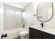 Modern bathroom featuring tiled shower-tub, a sleek black vanity with quartz countertop and black fixtures, and wood-look flooring at 3914 Steinbeck Dr, Las Vegas, NV 89115
