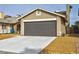 Detached two-car garage featuring a dark gray door, concrete driveway, and tasteful desert landscaping in a residential neighborhood at 3914 Steinbeck Dr, Las Vegas, NV 89115