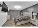 Comfortable bedroom features a mounted TV, a large bed, wood floors and modern lamps at 3930 University Center Dr # 909, Las Vegas, NV 89119