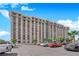 Exterior shot of a tall condo building with multiple windows, balconies, and ample parking at 3930 University Center Dr # 909, Las Vegas, NV 89119