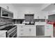 Well-equipped kitchen with stainless steel appliances, sleek white cabinetry, and tiled backsplash at 3930 University Center Dr # 909, Las Vegas, NV 89119