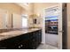 Double vanity bathroom featuring granite countertops, black cabinets, and an open doorway to a bedroom with bunkbeds at 4227 Diya Ave, North Las Vegas, NV 89084