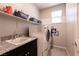 Modern laundry room with granite counters, sink, washer, and dryer combo, and ample storage on the shelf at 4227 Diya Ave, North Las Vegas, NV 89084