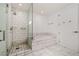 Bathroom showcasing a walk-in shower, soaking tub, and stylish white tiling with marble floors at 4471 Dean Martin Dr # 1207, Las Vegas, NV 89103